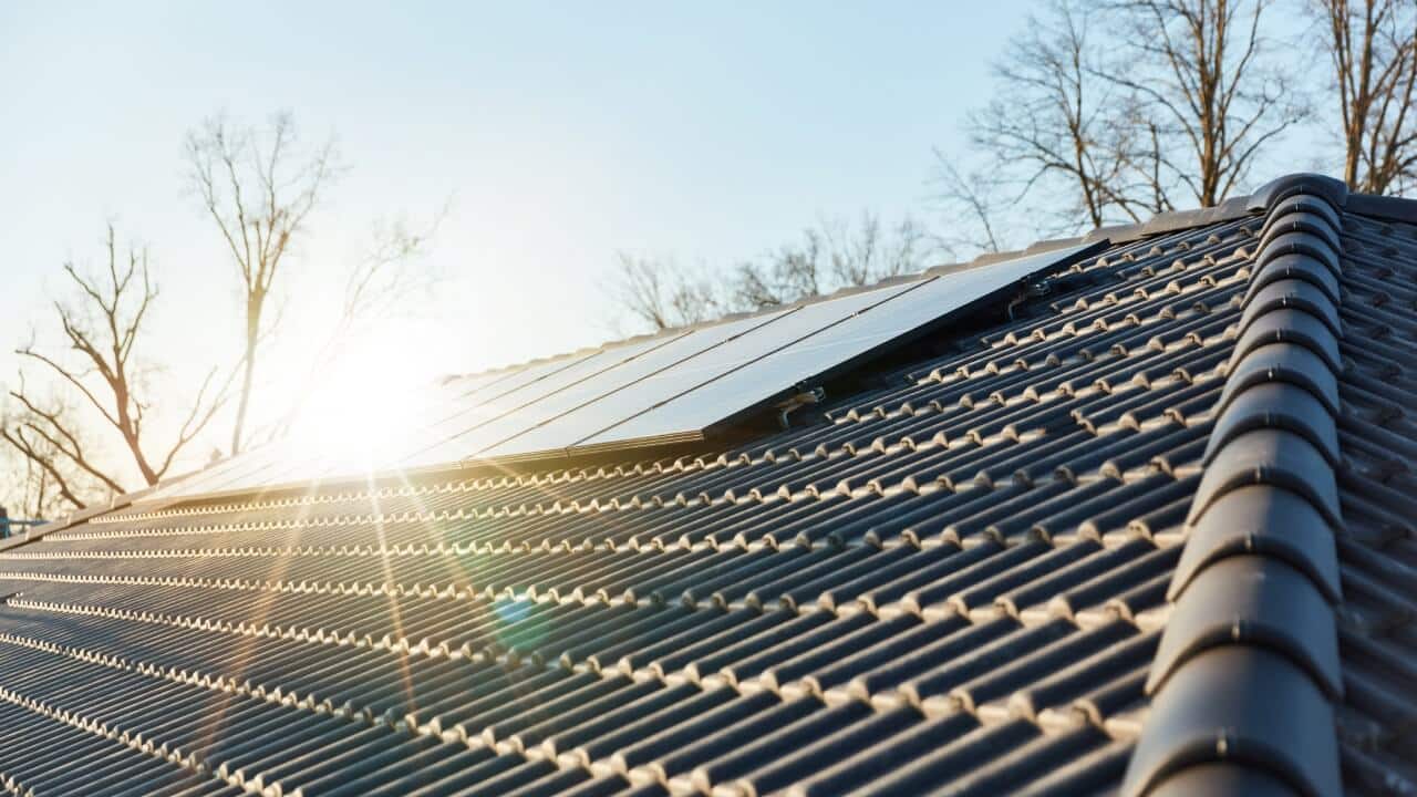 The sun shining on a solar panel system installed on the roof of a house. Your roof's orientation is something to consider in how solar panels are installed.